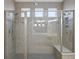 Custom tiled shower with dual shower heads, mosaic tile accent, and glass enclosure at 481 Blue Cypress Dr, Groveland, FL 34736