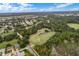 Expansive aerial view of a lush golf course winding through a residential community and beautiful trees at 4826 Summerbridge Cir, Leesburg, FL 34748