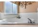 Close-up of a garden tub with white tile surround in a bathroom at 4826 Summerbridge Cir, Leesburg, FL 34748