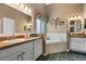 Bathroom featuring tile floors, dual sinks, and a tub with tile surround at 4826 Summerbridge Cir, Leesburg, FL 34748