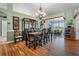 Elegant dining room with chandelier, wood floors, and view to the outdoor sunroom and landscaped yard at 4826 Summerbridge Cir, Leesburg, FL 34748