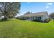 Rear exterior view of home with a well maintained lawn and a screened in lanai at 4826 Summerbridge Cir, Leesburg, FL 34748