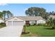 Charming single-story home with a red door, manicured lawn and a two car garage at 4826 Summerbridge Cir, Leesburg, FL 34748