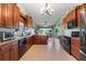 Spacious kitchen featuring wood cabinetry, granite countertops, stainless steel appliances, and tile flooring at 4826 Summerbridge Cir, Leesburg, FL 34748