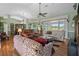 Inviting living room with a ceiling fan, comfortable sofas, and a view of the screened-in porch at 4826 Summerbridge Cir, Leesburg, FL 34748