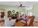 Inviting living room with high ceilings, a ceiling fan, bookshelves, and comfortable seating at 4826 Summerbridge Cir, Leesburg, FL 34748