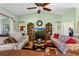 Comfortable living room with a ceiling fan, bookshelves, and plenty of seating at 4826 Summerbridge Cir, Leesburg, FL 34748