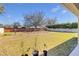 Lush backyard featuring a large grassy area with a brick wall perimeter and three potted plants in the foreground at 4951 Cypress Hammock Dr, St Cloud, FL 34771