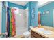 Bathroom featuring a shower-tub combo with bright colored shower curtain and matching blue walls at 4951 Cypress Hammock Dr, St Cloud, FL 34771