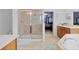 Bright bathroom with a glass-enclosed shower, a soaking tub, and neutral tiling at 4951 Cypress Hammock Dr, St Cloud, FL 34771