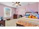 Pink bedroom with a ceiling fan, natural light, and soft carpet at 4951 Cypress Hammock Dr, St Cloud, FL 34771