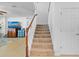 Carpeted staircase with white risers and wood handrail leading to the upper level of the home at 4951 Cypress Hammock Dr, St Cloud, FL 34771