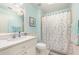 Cozy bathroom with white vanity, patterned shower curtain, and refreshing blue walls at 5370 Indian Ocean Loop, Tavares, FL 32778