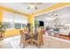 Sunny dining nook with a glass table, wicker chairs, and a large window overlooking a beautiful outdoor view next to living room at 5370 Indian Ocean Loop, Tavares, FL 32778