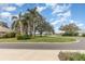 Community street view showcasing well-manicured lawns and mature trees in a quiet residential neighborhood on a sunny day at 5370 Indian Ocean Loop, Tavares, FL 32778