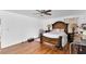 Well-lit main bedroom with hardwood floors, a comfortable bed, and side tables at 54 Pecan Pass, Ocala, FL 34472