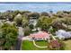 Aerial view of a beautiful home near the water surrounded by lush greenery and mature trees at 580 Page Ln, Mount Dora, FL 32757