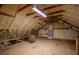 View of the unfinished attic showing the wood and beams with insulation applied to the ceilings and walls at 580 Page Ln, Mount Dora, FL 32757