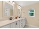 Bright bathroom with double vanity, white cabinets, framed mirrors, and neutral walls at 580 Page Ln, Mount Dora, FL 32757