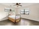 Bedroom with wood floors, two windows and a metal bed frame with a beige bed skirt at 580 Page Ln, Mount Dora, FL 32757