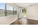 Bright entryway featuring hardwood floors, a window with blinds, and a partially open front door at 580 Page Ln, Mount Dora, FL 32757