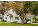 Charming home exterior with green grass, mature trees, and classic architectural details at 580 Page Ln, Mount Dora, FL 32757