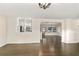 Spacious living room with dark wood floors that looks into the kitchen with a view of the backyard at 580 Page Ln, Mount Dora, FL 32757