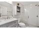 Bright bathroom with a glass shower, gray vanity, and marble countertop at 589 Sherwood St, The Villages, FL 32162