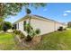 Back exterior view with a lush landscape, stone accents, and well-maintained lawn at 589 Sherwood St, The Villages, FL 32162