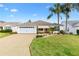 Charming single-story home featuring a well-manicured lawn and a two-car garage at 589 Sherwood St, The Villages, FL 32162