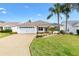 Charming single-story home featuring a well-manicured lawn and a two-car garage at 589 Sherwood St, The Villages, FL 32162