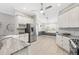 Bright kitchen with stainless steel appliances, farmhouse sink, and white cabinets, ideal for cooking and entertaining at 589 Sherwood St, The Villages, FL 32162