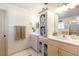 Bright bathroom featuring dual sinks with a cabinet, vanity, shower with glass doors, and tile floors at 5952 Brittania Blvd, Tavares, FL 32778