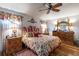 Comfortable bedroom featuring a ceiling fan, matching furniture set, and patterned bedding at 5952 Brittania Blvd, Tavares, FL 32778