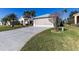 Wide concrete driveway leading up to a two-car garage with lush green grass surrounding the home at 5952 Brittania Blvd, Tavares, FL 32778