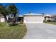 A well-maintained home featuring a paved driveway, two-car garage, and screened-in porch at 5952 Brittania Blvd, Tavares, FL 32778