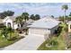 Well-manicured home featuring tropical landscaping and a paved driveway at 5952 Brittania Blvd, Tavares, FL 32778