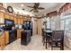 Traditional eat-in kitchen with natural wood cabinets, black appliances and adjacent dining table at 5952 Brittania Blvd, Tavares, FL 32778