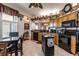 Bright eat-in kitchen featuring ample wooden cabinetry, black appliances and a tiled floor at 5952 Brittania Blvd, Tavares, FL 32778