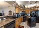 Traditional eat-in kitchen features stainless steel appliances, wooden cabinetry, and dark countertops at 5952 Brittania Blvd, Tavares, FL 32778