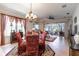 Formal living room features a ceiling fan, decorative chandelier, and sliding glass doors to the patio at 5952 Brittania Blvd, Tavares, FL 32778