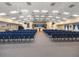 A large, carpeted meeting room with rows of blue chairs facing a stage with neutral colored walls at 5952 Brittania Blvd, Tavares, FL 32778