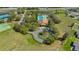 Aerial view of the community pool with clubhouse, a playground, and sports courts in a green setting at 6240 Tremayne Dr, Mount Dora, FL 32757