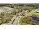 Community entrance featuring palm trees and lush landscaping with a pond adjacent to the main road at 6240 Tremayne Dr, Mount Dora, FL 32757