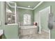 Bathroom featuring soaking tub with tiled surround, separate shower, and shuttered window at 6240 Tremayne Dr, Mount Dora, FL 32757