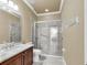 Bathroom featuring a glass-enclosed shower, granite vanity, tiled flooring, and neutral color scheme at 6240 Tremayne Dr, Mount Dora, FL 32757