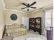 Cozy bedroom featuring a wrought iron bed frame, room divider, plantation shutters, and a ceiling fan at 6240 Tremayne Dr, Mount Dora, FL 32757