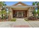 Clubhouse entrance featuring stone accents, a covered entryway, and manicured landscaping at 6240 Tremayne Dr, Mount Dora, FL 32757