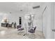 Modern dining area with a glass table, unique light fixture, and neutral tile flooring at 6240 Tremayne Dr, Mount Dora, FL 32757