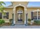 Elegant front entrance with decorative columns, brick walkway, and manicured greenery at 6240 Tremayne Dr, Mount Dora, FL 32757